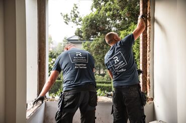 Twee Reynaers Aluminium installateurs ontmantelen oude ramen op locatie.