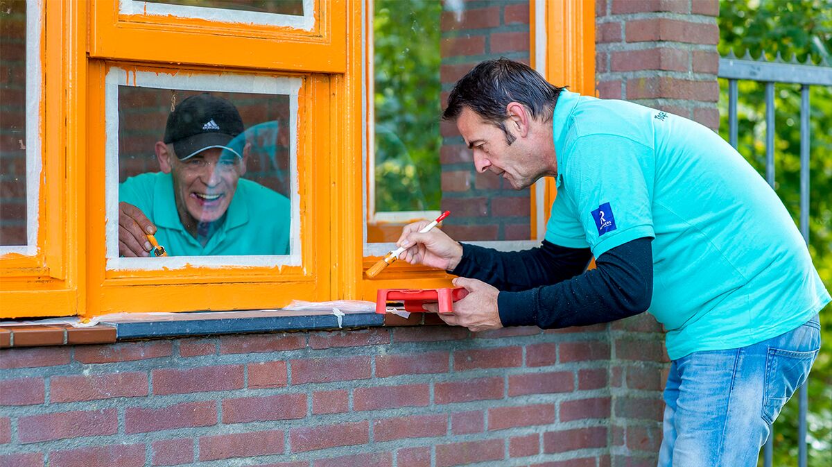 Reynaers Aluminium collega's schilderen een raam op de MVO-dag.