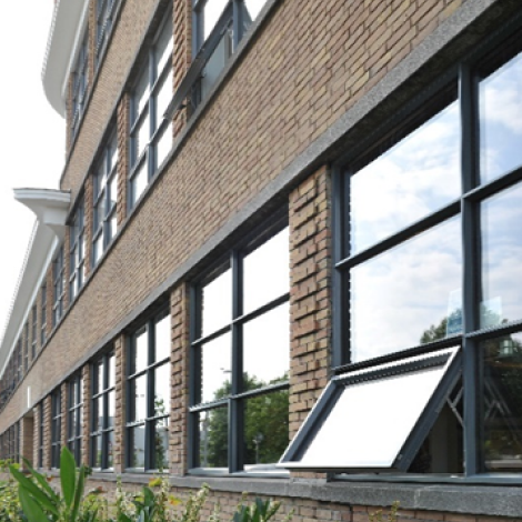 A brick building with a window open demonstrating natural ventilation