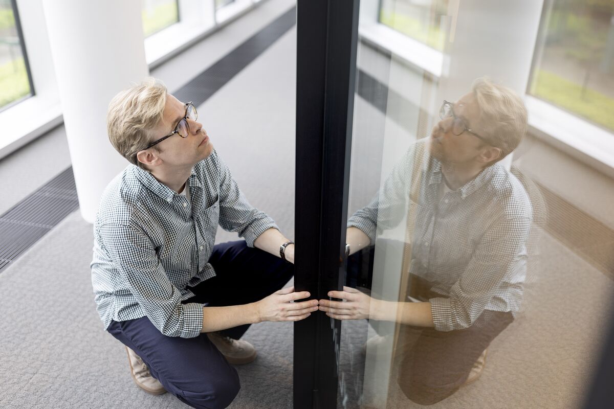 Man met bril houdt zwart aluminium profiel vast.