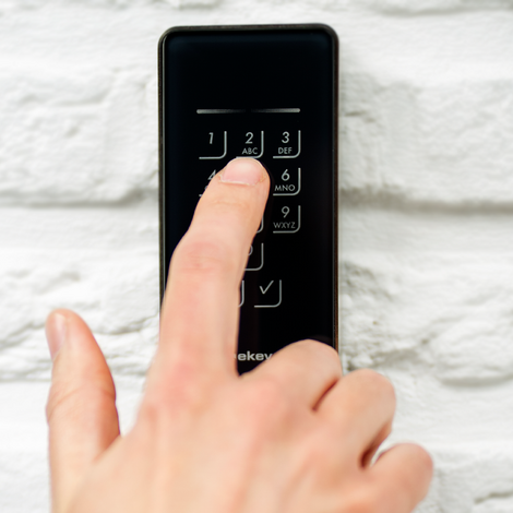 Close-up of hand using keypad access control feature.