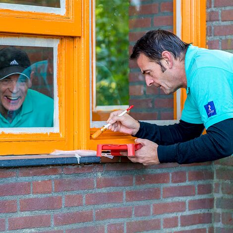 Reynaers Aluminium collega's schilderen een raam op de MVO-dag.