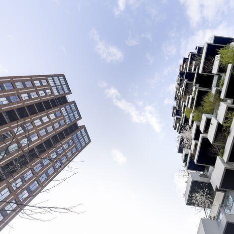 Brown and green high-rise tower as seen from below.