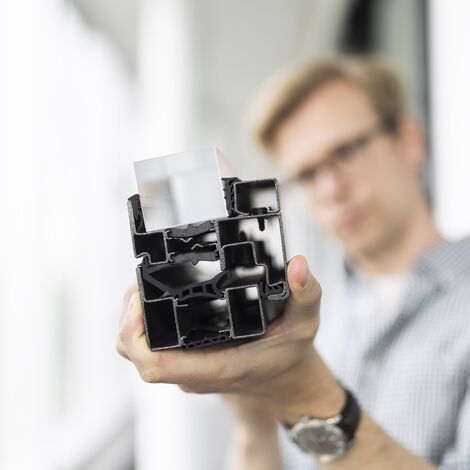 Man holding insulated profile sample close to the camera.