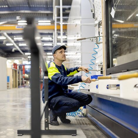 Testmedewerker knielt bij AWW-test op raam op Reynaers Campus.