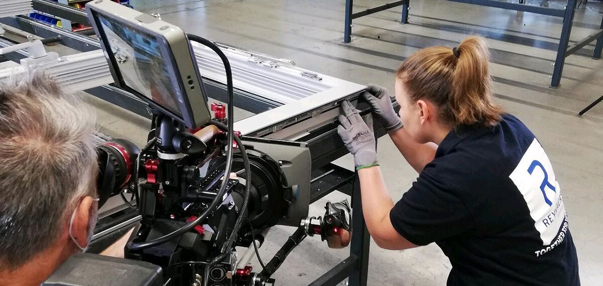 Filming a training video while fabricator assembles aluminium profiles.