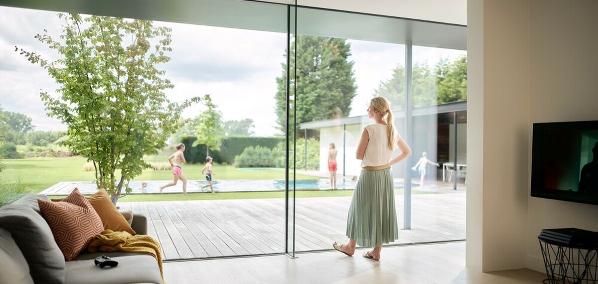 Vrouw in moderne woning met aluminium ramen