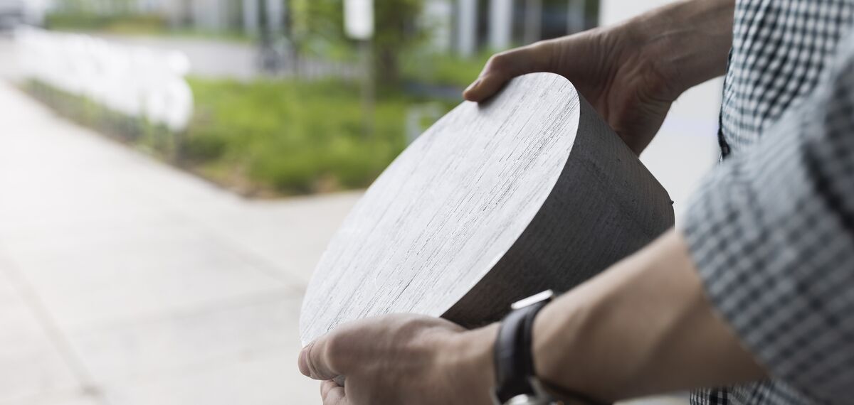 Persoon die cirkelvormig aluminium billetmateriaal vasthoudt.