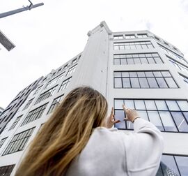 Blonde vrouw voor een wit gebouw in de stad