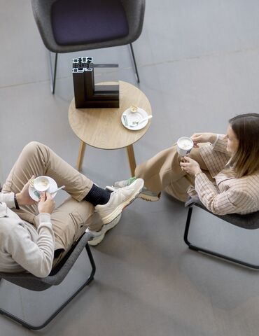 Bovenaanzicht van man en vrouw zittend aan een tafel, koffie drinkend.