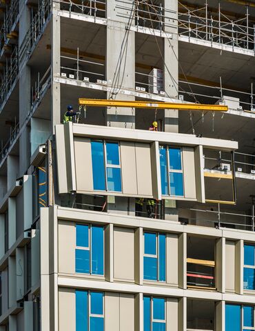 Beige hoogbouw met veel ramen in het centrum.